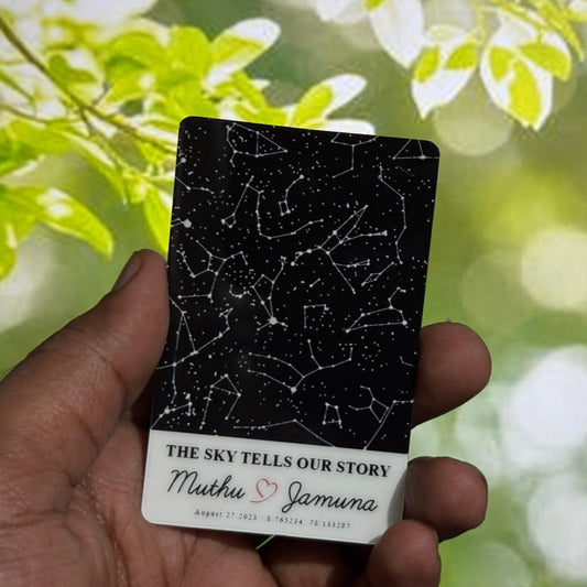 Hand holding a card with star map design against a blurred natural background